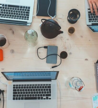 des gens assis près d'une table avec des ordinateurs portables assortis